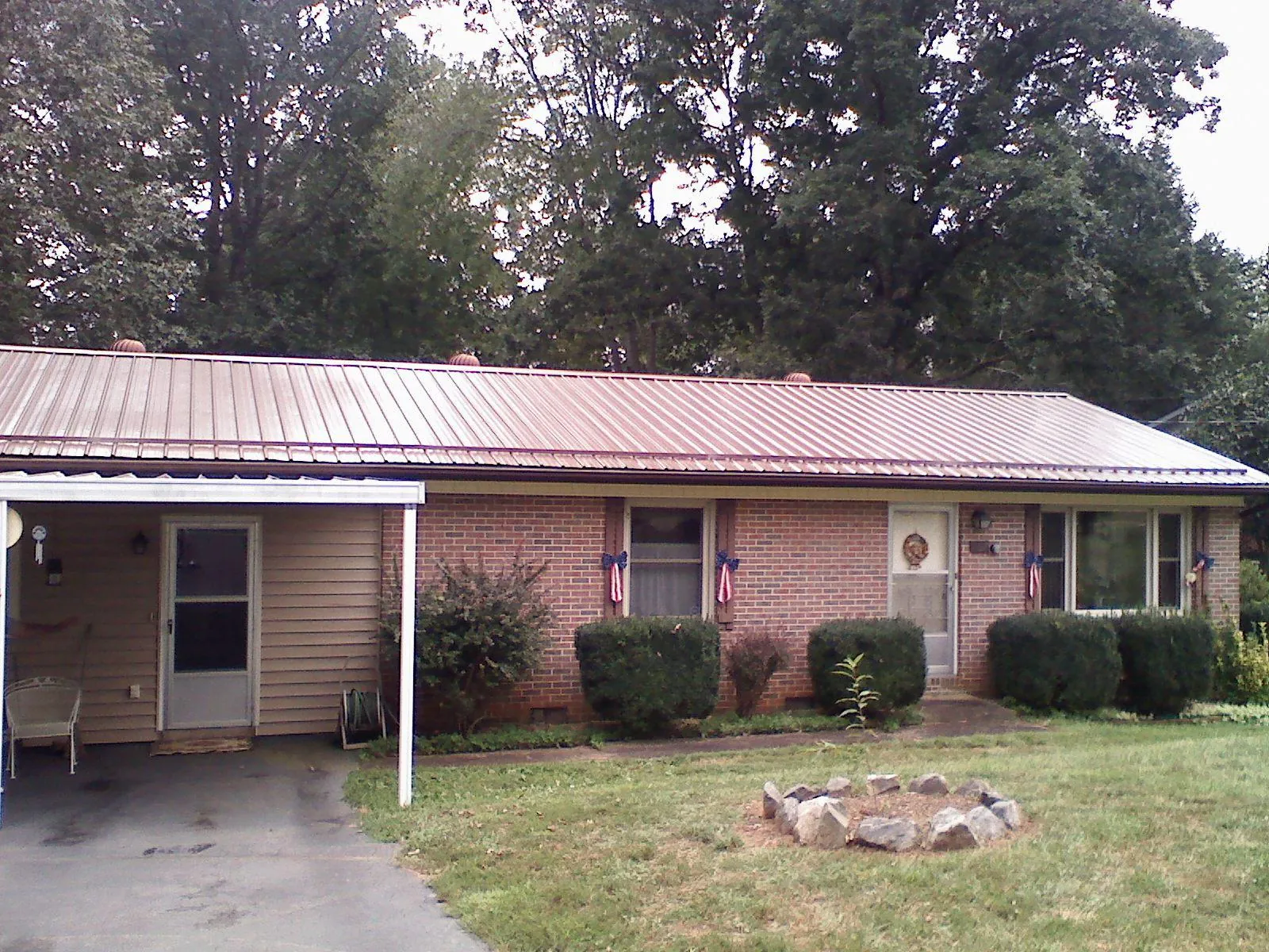 Bronze metal roof and carport on a brick ranch home — Roof Repair work by our crew in Hawthorne
